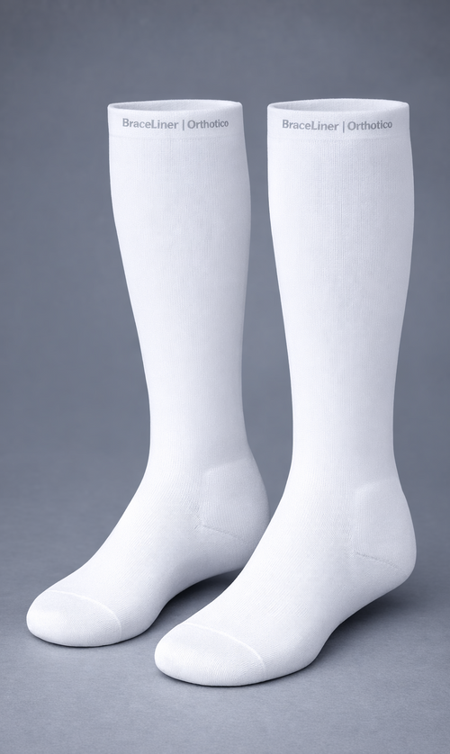 Pair of white knee-high socks on a gray background