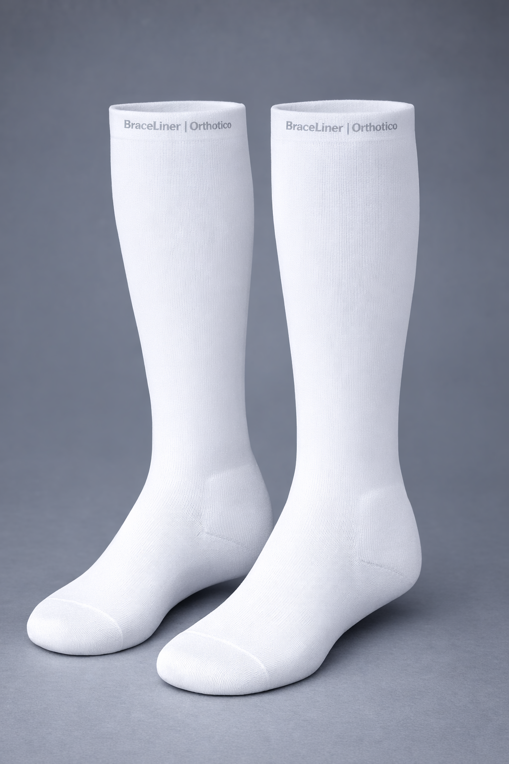 Pair of white knee-high socks on a gray background