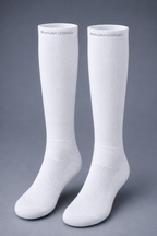 A pair of white knee-high orthopedic socks with textured knit arch support and ventilation zones, displayed on a neutral gray background. The brand name 'BraceLiner | Orthotics' is printed near the top cuff of each sock.