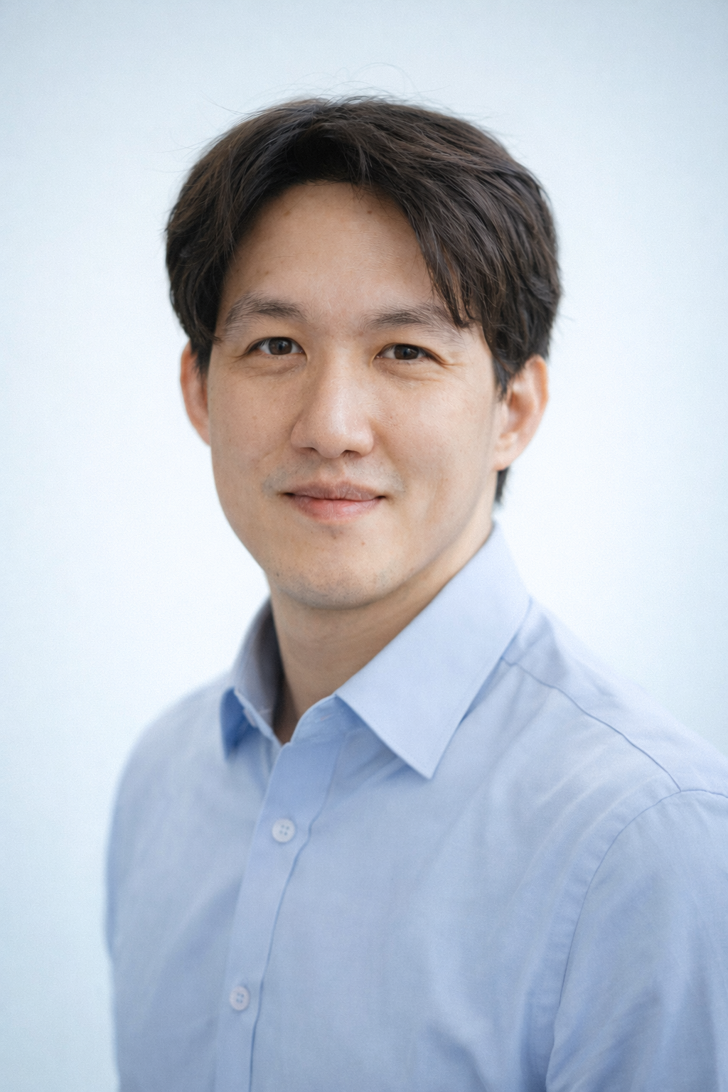 Man wearing a light blue shirt against a white background