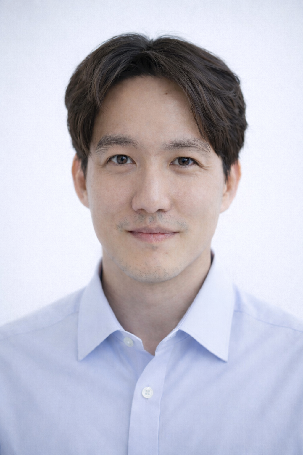 Man wearing a light blue shirt against a white background